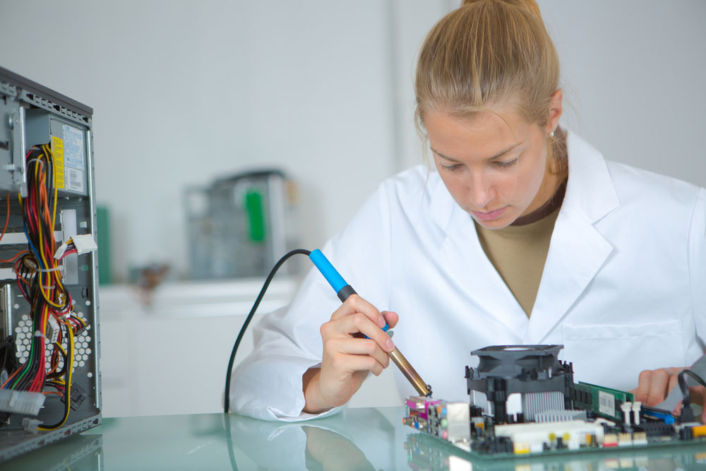 A young lady soldering in an electronics lab