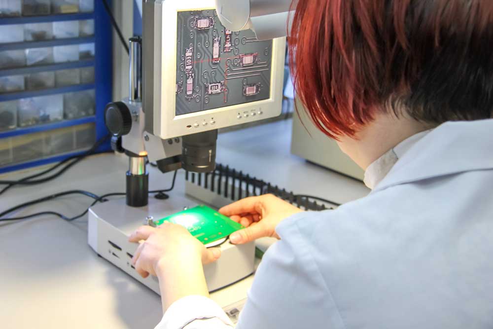 An engineer inspecting a PCB visually